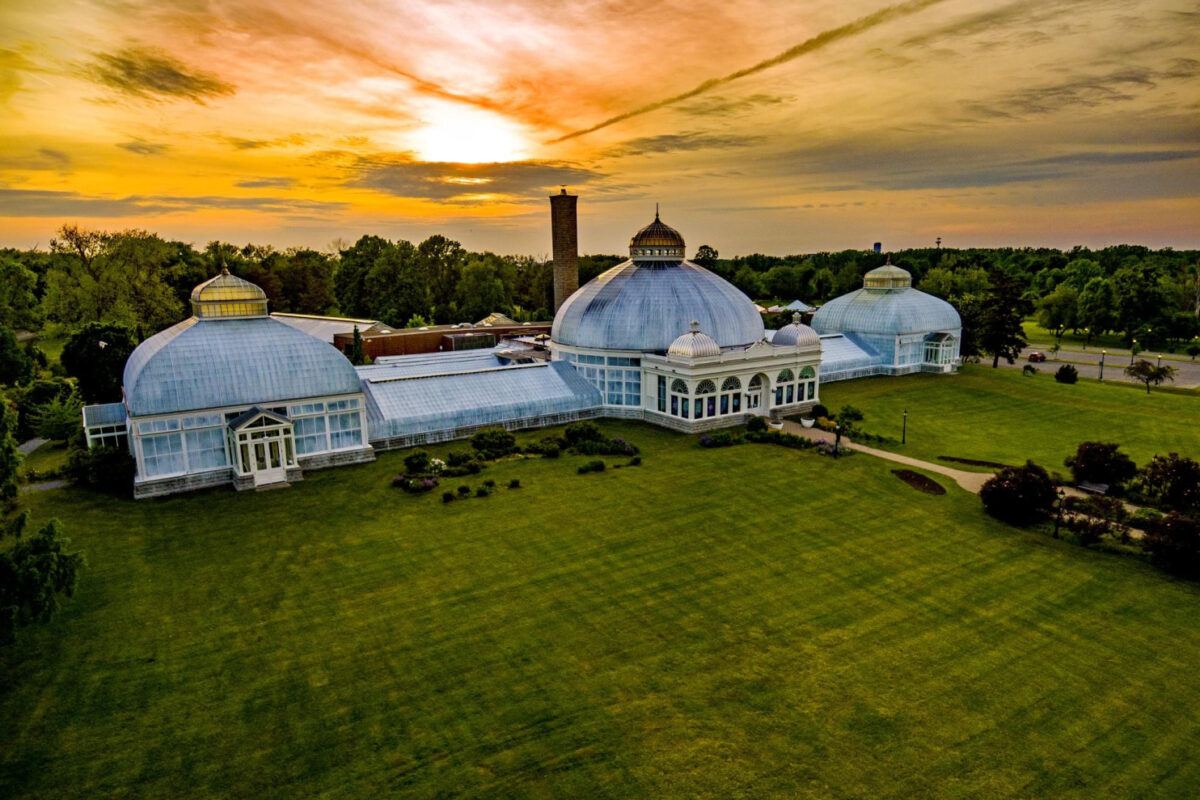 Aerial image of the Buffalo and Erie County Botanical Gardens with an orange sunset in the background.